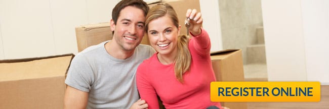 Couple in new house with keys and moving boxes