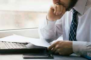 Man at a computer deciding what debt management program to use