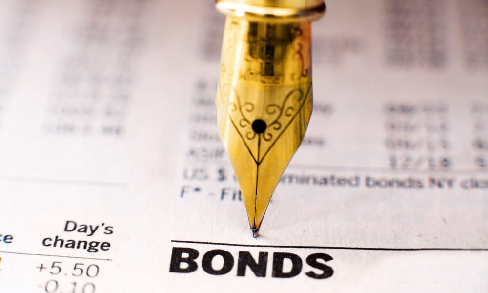 Photo of gold pen writing on bond indices paper