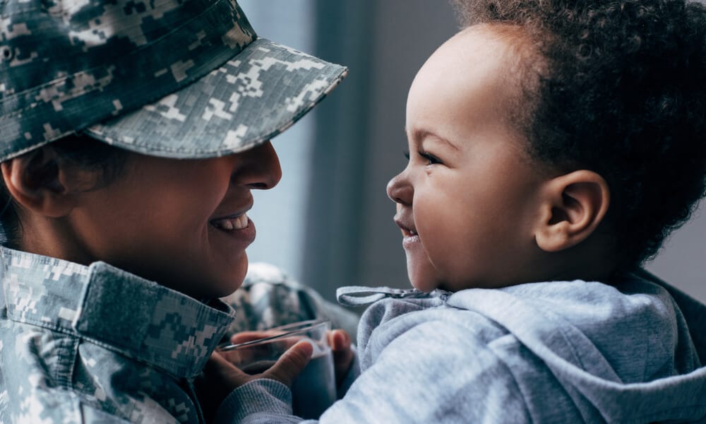 Smiling military mother and child look each other in the eyes happily
