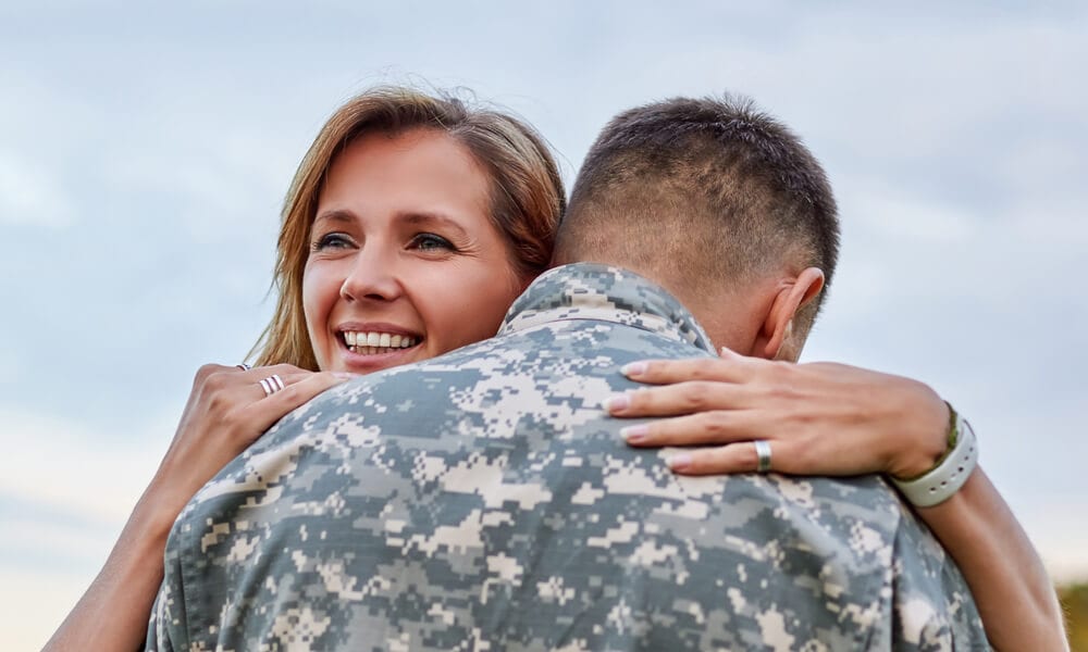 Military wife hugging husband who recently came back from duty