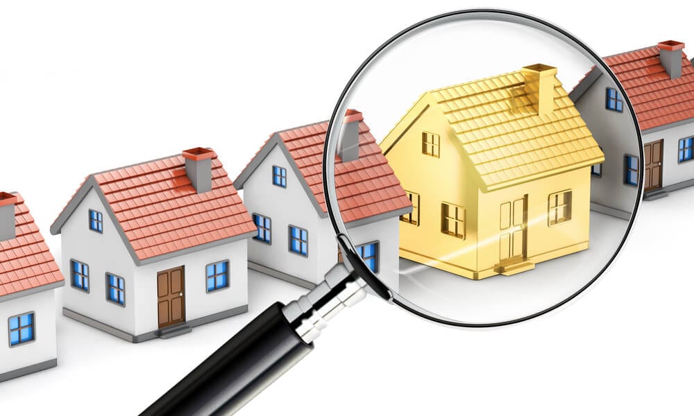 Magnifying glass glossing over model homes landing on golden home