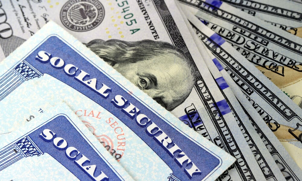 Social Security cards on top of stack of 100 dollar bills