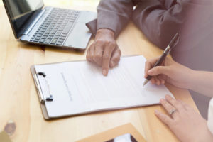 Woman signing mortgage loan application