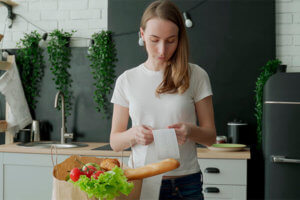 Woman looking at receipt showing more expensive grocery items after inflation