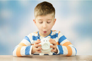 A young child holding a piggy bank to save his money in