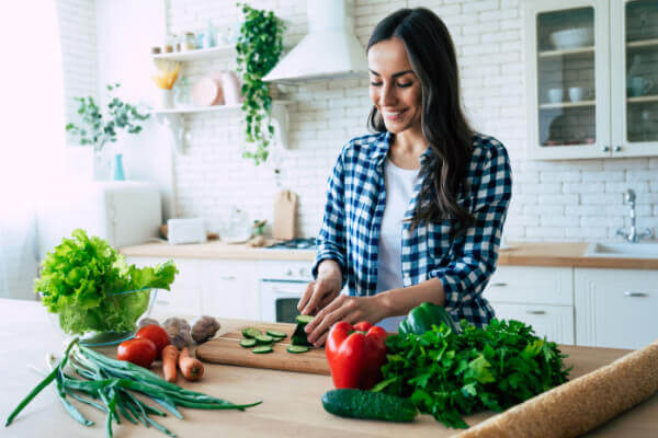 Woman planning her meal for the night on the kitchen counter