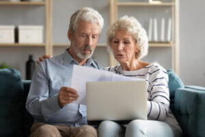 Elderly couple discussing their options with debt collectors