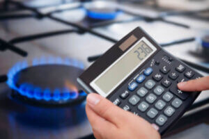 Woman using a calculator to determine her gas bill savings