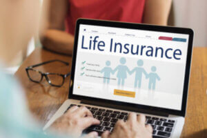 Senior researching life insurance options on computer