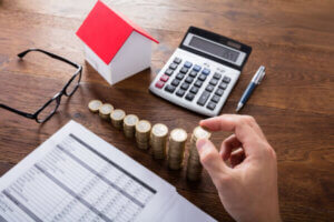 Man averaging out his monthly expenses with a calculator