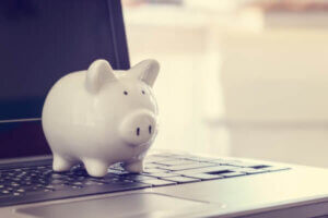 White piggy bank on a laptop computer, depicts high-yield savings account.
