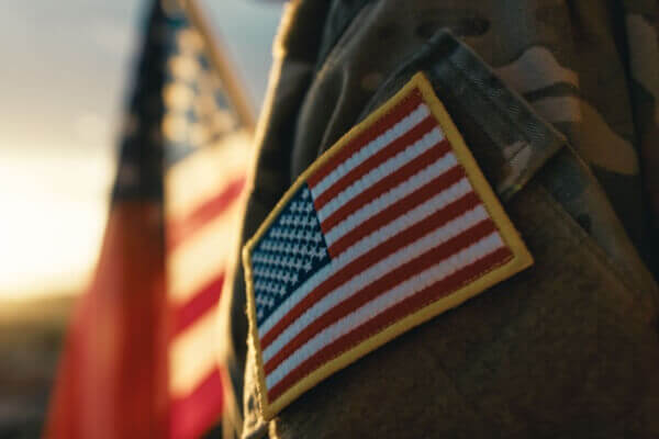 Military servicemember standing in front of the American flag
