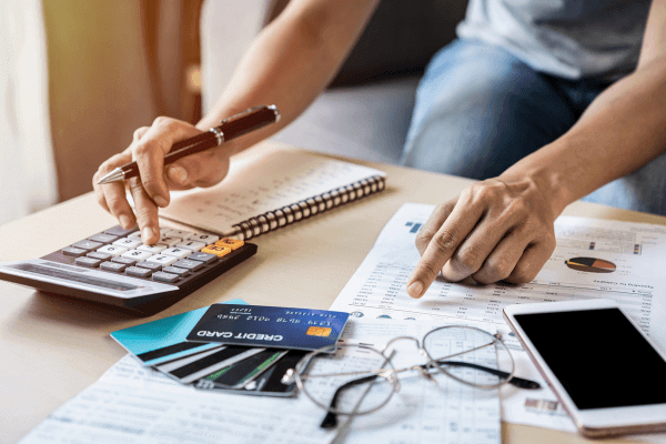 Young woman checking and calculating credit card payments at home.