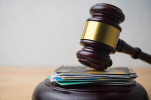 Close up judge hammer gavel on many credit card with white wall background