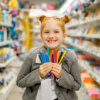 A young girl holding school supplies
